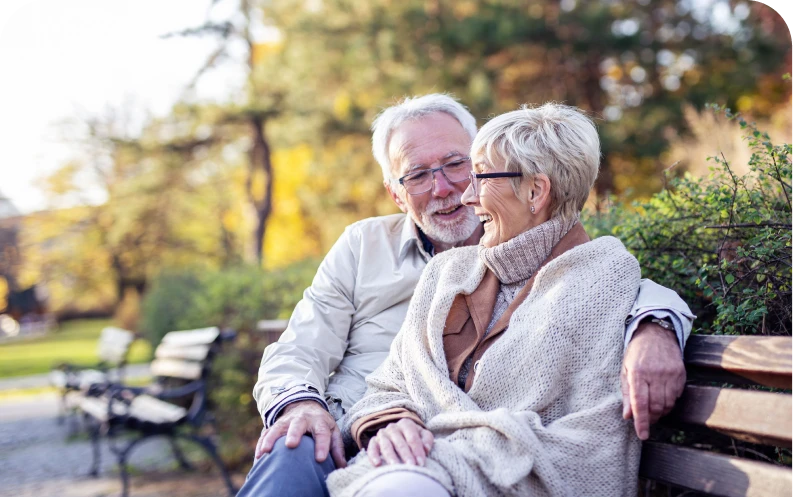 Senior couple sitting and enjoying a sunny day in the park together