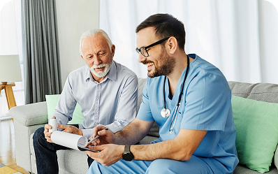 Healthcare worker in scrubs reviewing documents with an elderly man in a living room setting