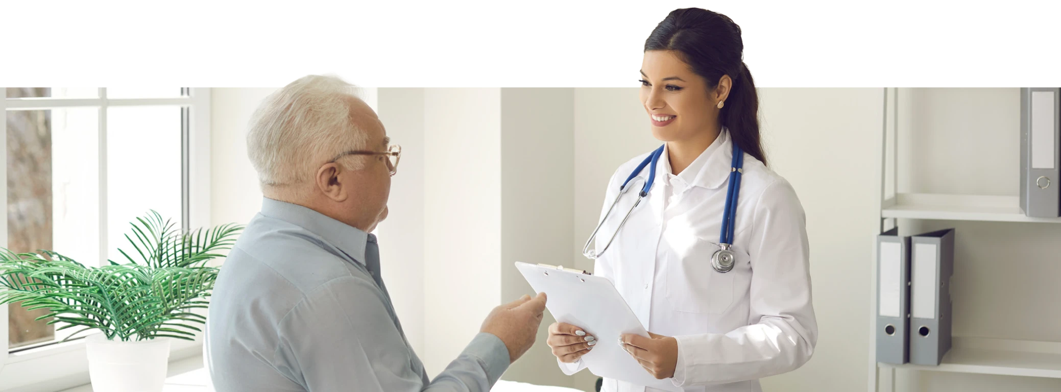 Doctor handing medical form to senior patient in office, Healthcare setting with plant and files