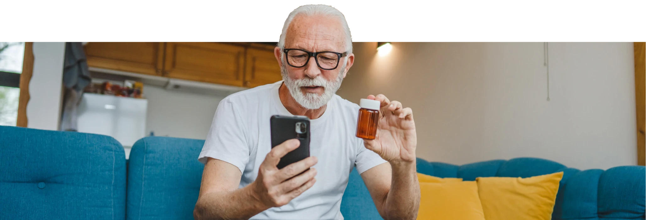 Senior man on telehealth call, holding medication