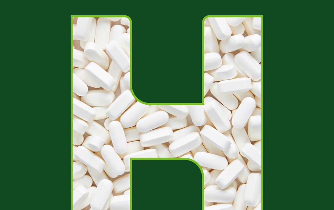 Letter 'H' shaped outline filled with numerous white oblong pills or tablets on a white background