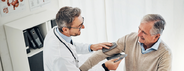 A doctor checks the blood pressure of an elderly patient in a bright medical office