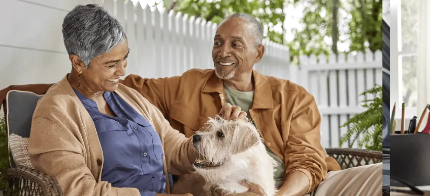 A old couple sitting in a table with dog